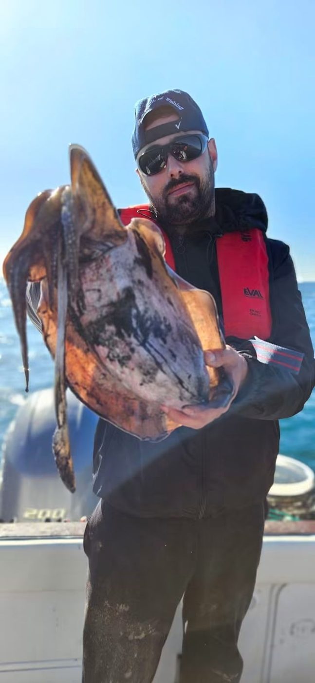 Pescador de boné segura um choco grande